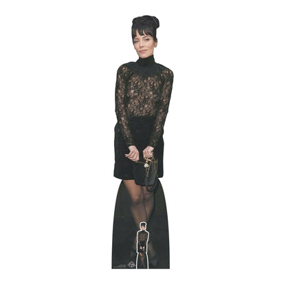 Lifesize cardboard cut out of a female celebrity Lilly Allen with black hair and a black dress, holding an award.