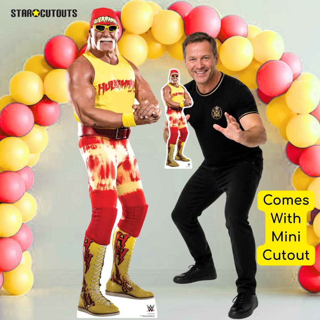 A WWE wrestler cardboard cutout styled as a full-body figure in a yellow tank top, red tie-dye pants, and gold boots, shown next to a smaller matching mini cutout. The scene is decorated with a red and yellow balloon arch, and a yellow text box says 'Comes With Mini Cutout'.